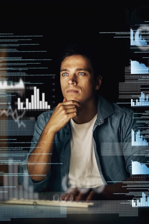 Cropped shot of a young computer programmer looking through data in the dark.